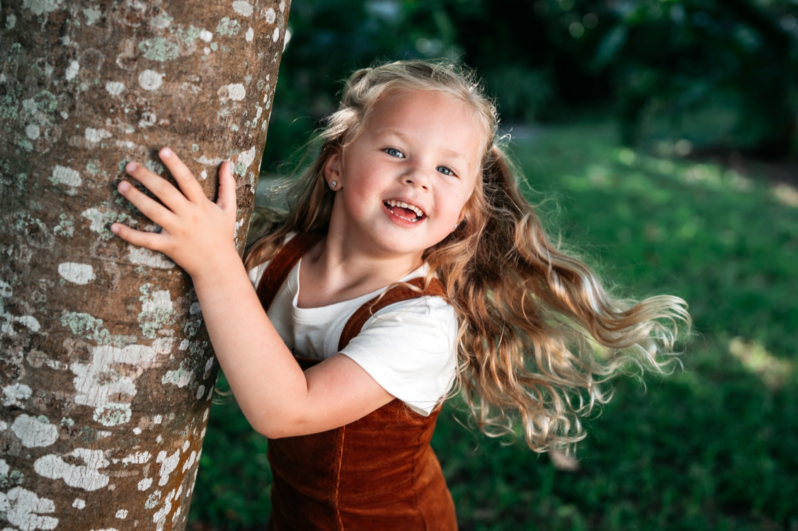 Isla laughing by a tree